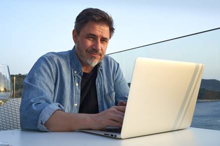 Büroleiter am Laptop auf einer Terrasse