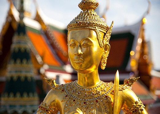 Goldene Buddha-Figur vor einem thailändischen Tempel